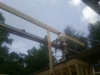 Carpenter setting a ridge beam over a new addition frame — Ice Dam Removal by Roofing Brothers in Verbena