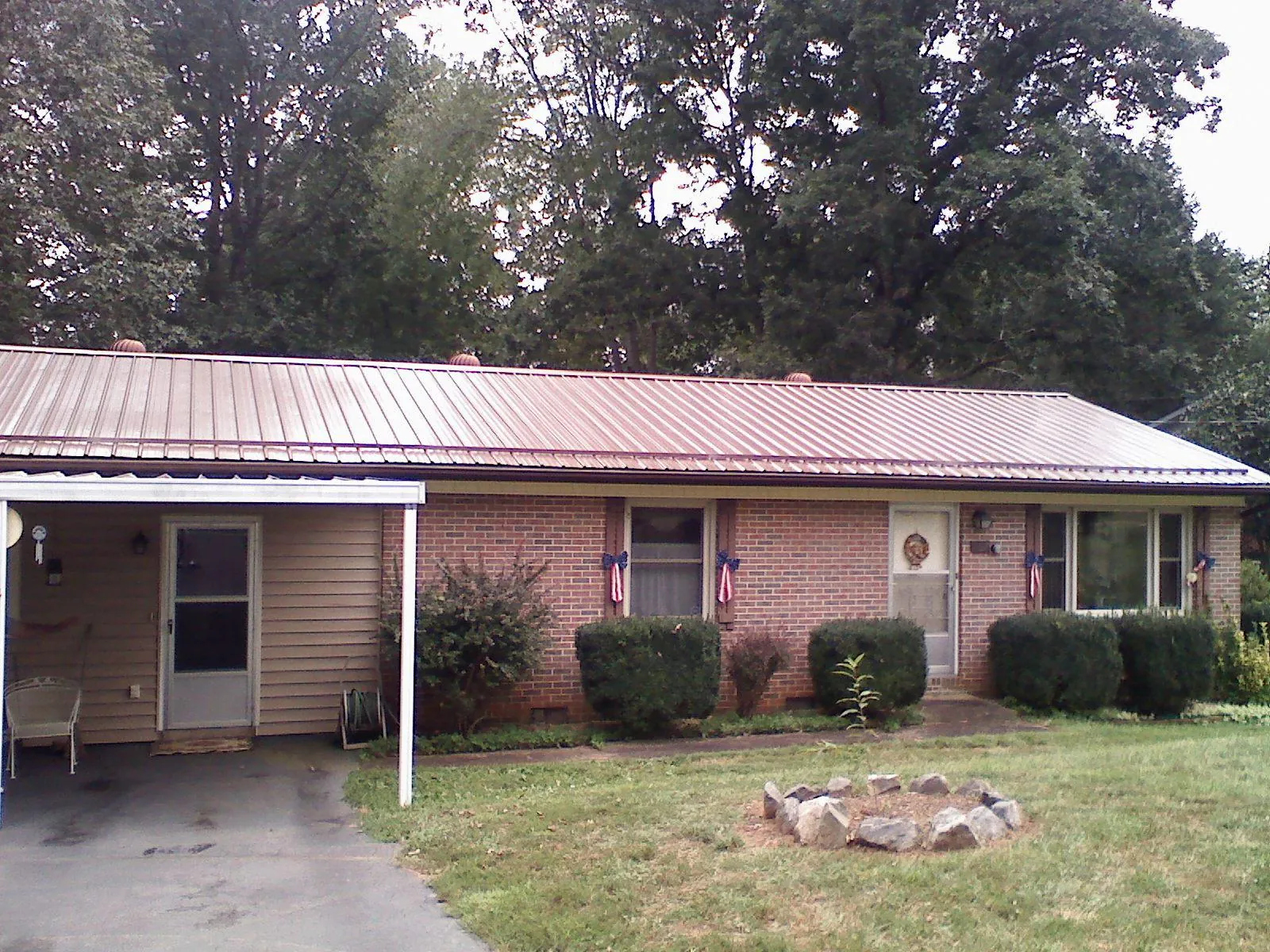 Bronze metal roof and carport on a brick ranch home — Roof Repair work by our crew in Verbena
